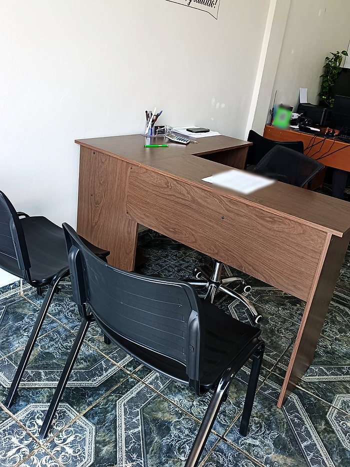 Mesa de atendimento aos clientes, com cadeiras e o ambiente do escritório